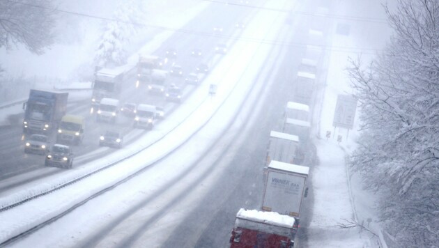 Stau auf der Autobahn 8 in Bayern wegen des Schneefalls (Bild: AP)
