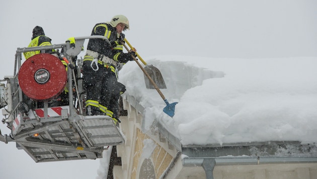 Feuerwehrleute in Spital am Pyhrn beim Schneeschaufeln von einem Dach (Bild: © Jack Haijes)