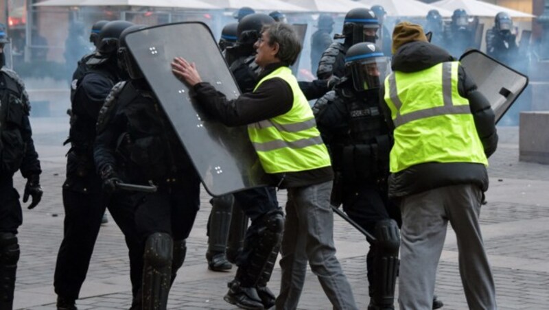 Diese „Gelbwesten“ in Toulouse haben keinerlei Berührungsängste. (Bild: APA/AFP/PASCAL PAVANI)