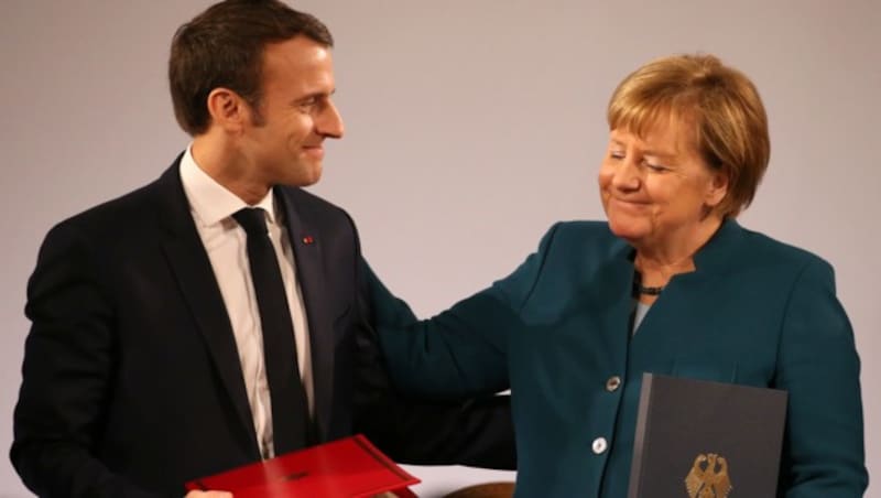 Frankreichs Präsident Emmanuel Macron und Deutschlands Kanzlerin Angela Merkel nach der Unterzeichnung des Vertrags (Bild: APA/dpa/Oliver Berg)