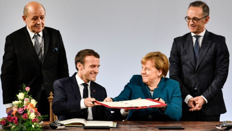 Die beiden Regierungschefs Macron und Merkel bei der Unterzeichnung des Freundschaftsvertrags, flankiert von ihren Außenministern Heiko Maas (rechts) und Jean-Yves Le Drian (links) (Bild: AP)