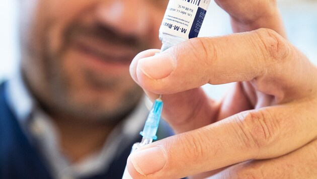 Ein Kinderarzt zieht den Masernimpfstoff in die Spritze auf. (Bild: APA/Georg Hochmuth)
