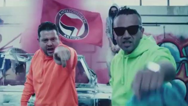 Wie die Fahne im Hintergrund offenbart, halten die Rapper den Song für eine „antifaschistische Aktion“. (Bild: youtube.com)