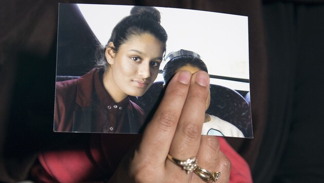 Die ältere Schwester hält ein Bild von Shamima Begum in der Hand. Die junge Britin war 2015 zum IS nach Syrien ausgereist und will jetzt wieder in ihre Heimat zurück. (Bild: AFP)