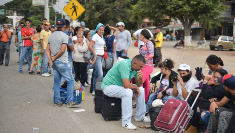 Diese Venezolaner stehen vor einer Wechselstube Schlange, um ausländisches Geld, das ihnen Verwandte geschickt haben, umzutauschen. (Bild: APA/AFP/Luis ROBAYO)