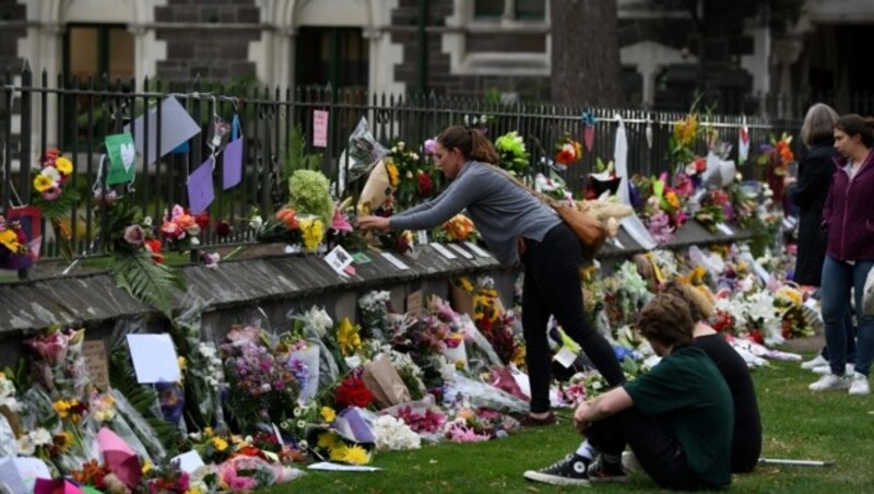 Trauernde legen Blumen im Gedenken an die Opfer nieder. (Bild: AFP)