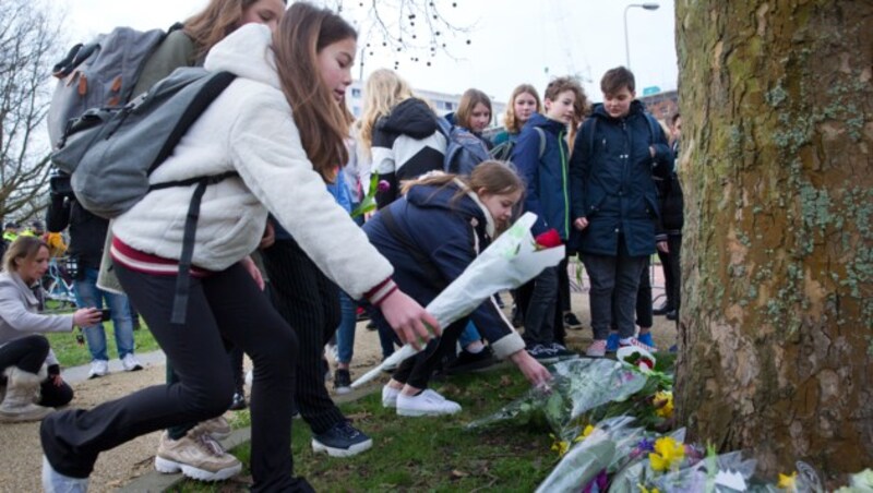 Trauernde Menschen legen Blumen an dem Ort ab, wo sich die Tragödie ereignete. (Bild: AP)