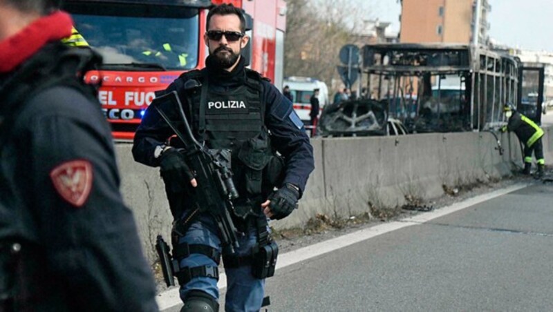 Auch schwer bewaffnete Polizei war vor Ort. Der Busfahrer, der sein Fahrzeug in Brand gesteckt hatte, war bereits als gewalttätig amtsbekannt. (Bild: AP)