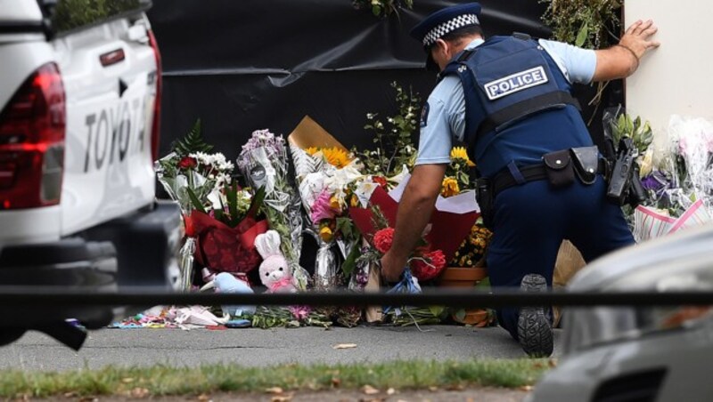 Ein Polizist legt in Christchurch vor der Al-Noor-Mosche, einem der beiden Schauplätze des Dramas, Blumen nieder. (Bild: AFP )