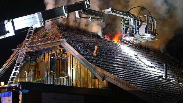 Aus dem Dach des Holzhauses schlugen den Einsatzkräften Flammen entgegen. (Bild: laumat.at/Matthias Lauber)