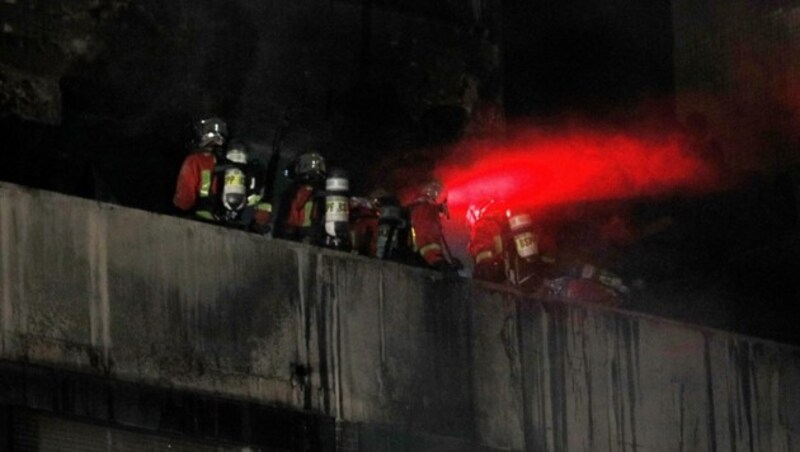 Mehrere Einsatzkräfte auf dem Balkon des Gebäudes (Bild: AFP )