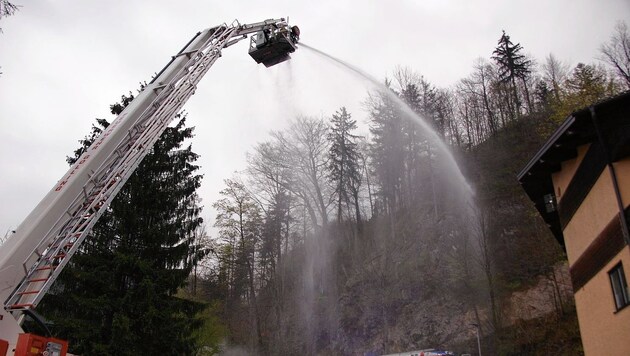 Drei Feuerwehrmänner löschten hoch oben von der Drehleiter aus. (Bild: FF Golling)