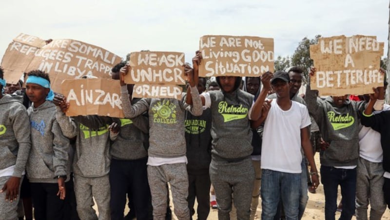 Migranten weisen auf die schlechten Zustände im libyschen Internierungslager in der Stadt Ain Zara hin. (Bild: AFP)