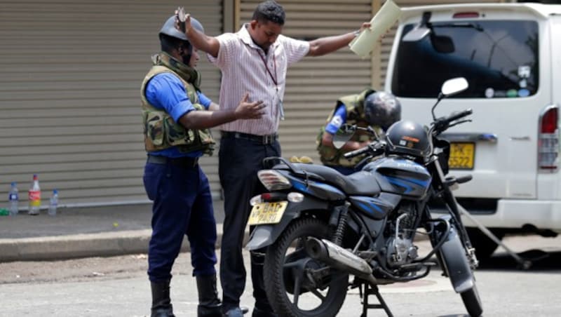 Die Lage auf Sri Lanka bleibt angespannt. Soldaten durchsuchen Menschen auf der Straße. (Bild: AP)