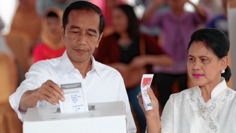 Indonesiens Präsident Joko Widodo mit seiner Ehefrau Iriana bei der Stimmabgabe (Bild: AP)