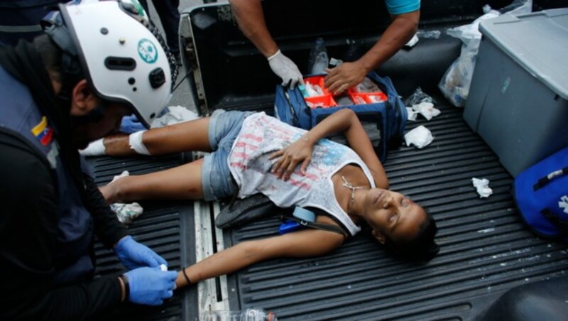 Eine verletzte Demonstrantin musste medizinisch behandelt werden. (Bild: AP)