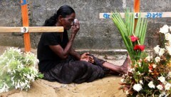 Eine Frau trauert am Grab ihrer bei dem Anschlag in der St.-Sebastian-Kirche in Negombo im Westen des Landes getöteten Tochter. Alleine in diesem Gotteshaus verloren mehr als 100 Menschen ihr Leben. (Bild: AP)