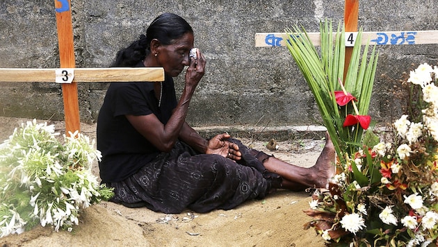 Eine Frau trauert am Grab ihrer bei dem Anschlag in der St.-Sebastian-Kirche in Negombo im Westen des Landes getöteten Tochter. Alleine in diesem Gotteshaus verloren mehr als 100 Menschen ihr Leben. (Bild: AP)