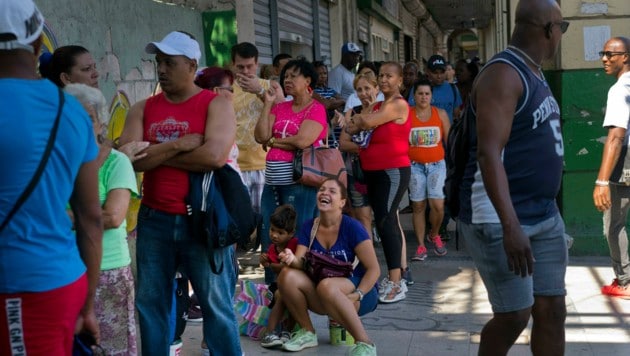 Menschen warten vor einem von der Regierung betriebenen Geschäft in Havana darauf, Lebensmittel kaufen zu dürfen. (Bild: AP)