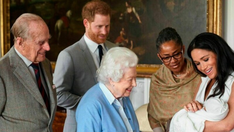 Prinz Harry und Herzogin Meghan zeigen den stolzen (Ur-)Großeltern - neben Queen Elisabeth II. und Prinz Philip ist auch Meghans Mutter Doria Ragland dabei - den kleinen Archie. (Bild: AP)