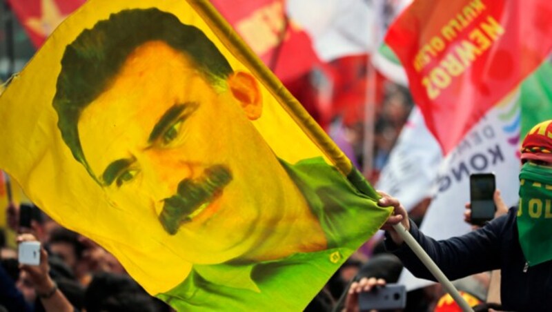 Eine PKK-Kundgebung mit einer Flagge des Anführers Abdullah Öcalan (Bild: AP)