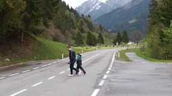 Simon Walch demonstriert mit seinem Sohn Jona das tägliche Überqueren der Lechtaler Bundesstraße zur Haltestelle. Dort sind 100 km/h erlaubt. (Bild: Daum Hubert)