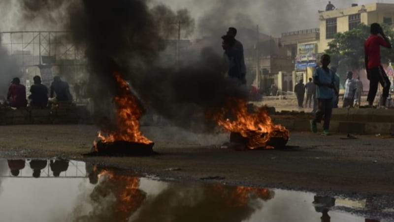 Sudanese protesters walk past burning tyres during a demonstration in Khartoum's twin city of Omdurman on June 3, 2019. - At least five protesters were shot dead Monday as Sudan's military rulers tried to break up a sit-in outside Khartoum's army headquarters, a doctors' committee said as gunfire was heard from the site. (Photo by Ahmed Mustafa / AFP) (Bild: AFP )