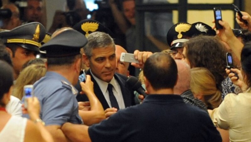 Einsatzkräfte hatten während des Prozesses in Mailand alle Hände damit zu tun, den prominenten Zivilkläger Clooney an der Presse vorbeizuschleusen. (Bild: AFP)