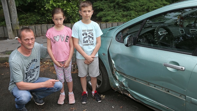 Sandor D. mit Tochter Julia (8) und Sohn Julian (11) neben dem demolierten Auto (Bild: Peter Tomschi)