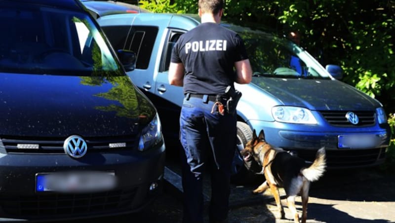 Mit Hunden und Baggern sucht die Polizei im Garten des Verdächtigen nach Kinderleichen. (Bild: APA/dpa/David Young)