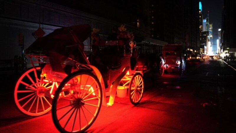 Beleuchtete Kutschen und Scheinwerfer der Autos spendeten im dunklen Manhattan ein wenig Licht. (Bild: AFP)