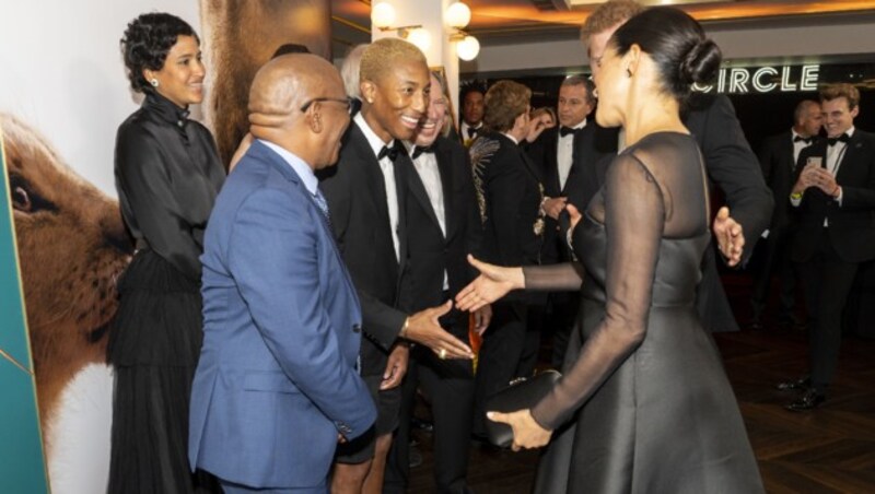 Prinz Harry und Herzogin Meghan begrüßen US-Sänger Pharrell Williams bei der Europa-Premiere des Films „König der Löwen“ (Bild: AFP)