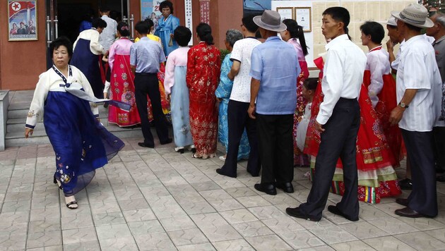 Nordkoreaner warten vor auf einem Wahllokal, bis sie mit ihrer Stimmabgabe an der Reihe sind. (Bild: AP)