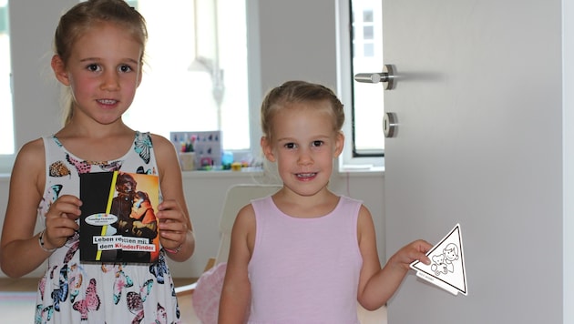Clara und Catharina (r.) haben ihre Kinderzimmertüre bereits mit dem „KinderFinder“ versehen. (Bild: FF Gmunden)