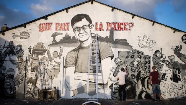 Graffiti-Künstler bemalen die Wände mit einem Bild von Steve Canico und Szenen aus der Todesnacht. (Bild: AFP)