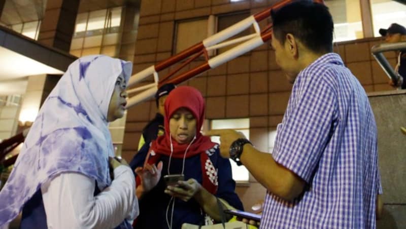 Sobald sie im Freien waren, verständigten zahlreiche Bewohner Jakartas ihre Angehörigen, dass es ihnen gut geht. (Bild: AP)
