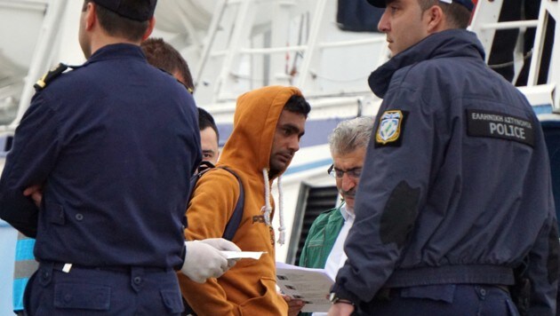 Frontex-Beamte durchsuchen Migranten. (Bild: AFP)