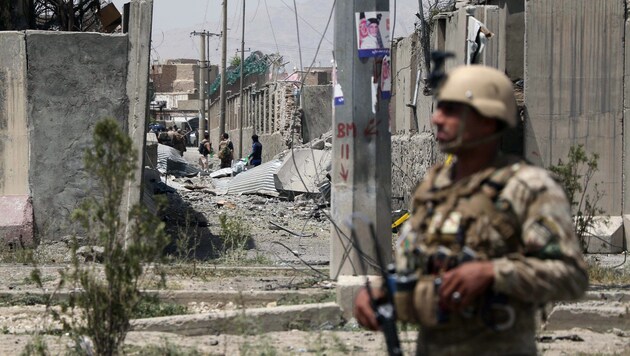 Ein afghanischer Soldat bewacht das Gelände, wo die Autobombe gezündet wurde. (Bild: AFP)