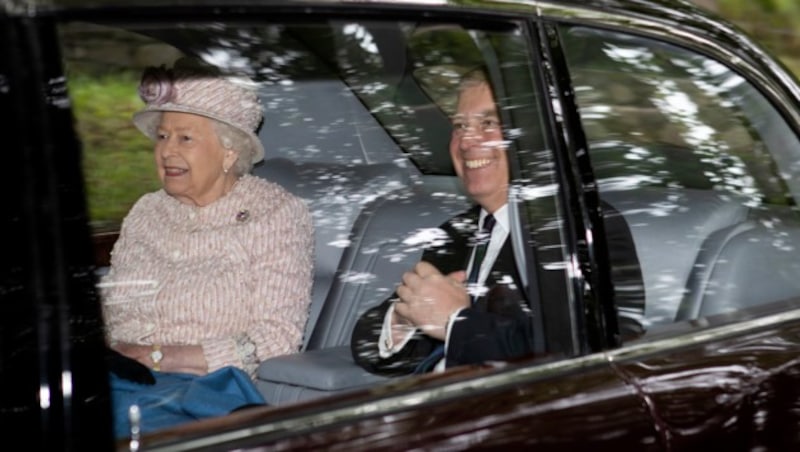 Queen Elizabeth II. und ihr Sohn Prinz Andrew lachen nach einem gemeinsamen Kirchenbesuch in Schottland aus dem Auto für die Fotografen. (Bild: AP)