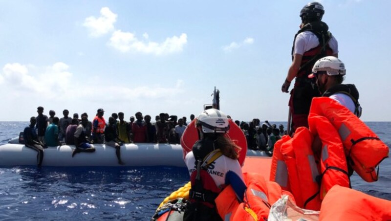 Crewmitglieder des NGO-Schiffs Ocean Viking bei der Rettung von Migranten in einem Schlauchboot (Bild: APA/AFP/Anne CHAON)