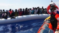 Ein Crewmitglied der Ocean Viking bei der Rettung von Migranten in einem Schlauchboot (Bild: AFP )