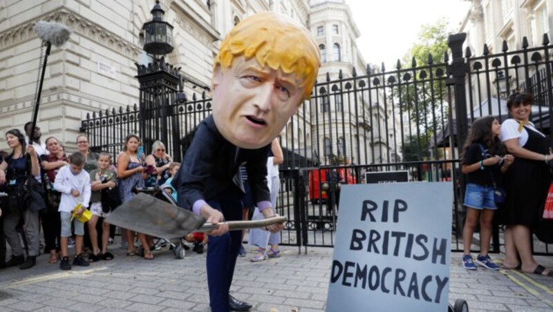 Ein Demonstrant vor dem Regierungssitz in London beerdigt symbolisch die britische Demokratie. (Bild: AP)