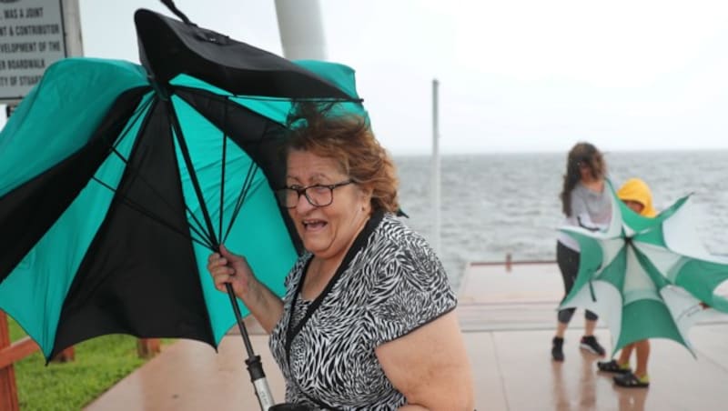 Eine Frau aus Florida stellt sich mit Regenschirm dem stürmischen Wetter entgegen. (Bild: 2019 Getty Images)