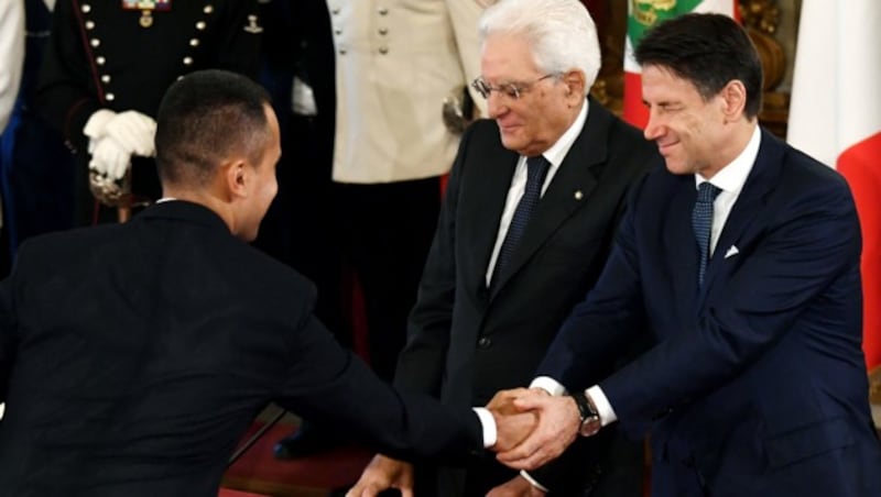 Luigi Di Maio (l.), Giuseppe Conte (r.) und Sergio Mattarella bei der Vereidigung (Bild: AFP)