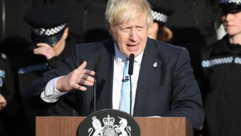 Während Boris Johnson spricht, geht es der Kadettin links hinter ihm immer schlechter. (Bild: AFP)