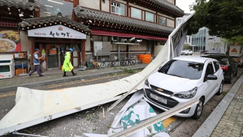 Eine Werbetafel wurde in Seoul umgeweht. (Bild: AP)