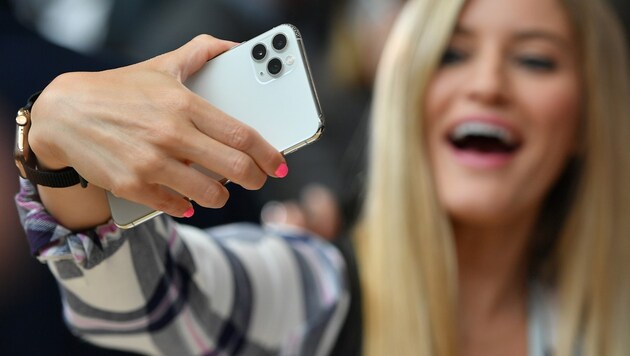 Eine Influencerin macht für ihre Gefolgschaft ein Selfie mit Apples iPhone 11 Pro. (Bild: APA/AFP/Josh Edelson)