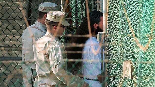 US-Soldaten mit einem Guantanamo-Häftling (Bild: AFP)