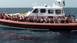 Italienische Küstenwache mit Migrantinnen und Migranten (Bild: AFP)