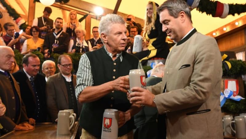 Dieter Reiter, Oberbürgermeister von München, überreicht Markus Söder, Ministerpräsident von Bayern, nach dem traditionellen Fassanstich das erste Maß. (Bild: APA/dpa/Sven Hoppe)